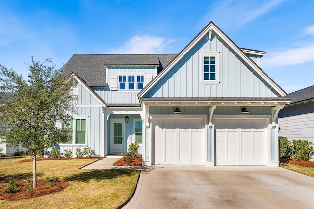 modern inspired farmhouse featuring driveway, a shingled roof, a front lawn, and board and batten siding