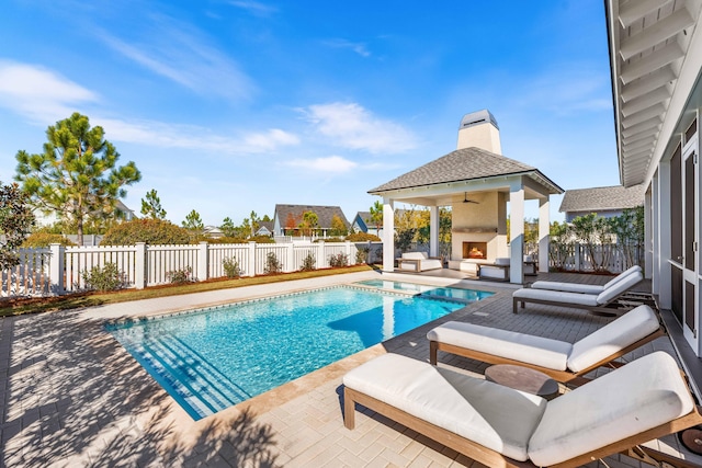 view of swimming pool featuring a patio area and an outdoor fireplace