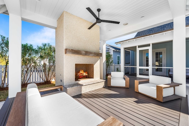 wooden terrace with fence, an outdoor living space with a fireplace, ceiling fan, and a sunroom