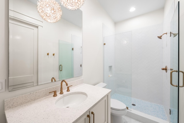 bathroom featuring vanity, an inviting chandelier, recessed lighting, a stall shower, and toilet