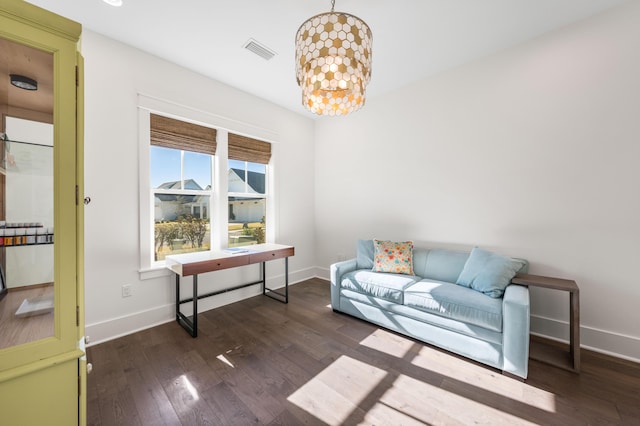 sitting room with dark wood-type flooring and a notable chandelier