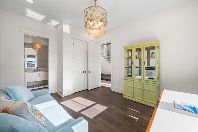 interior space featuring an inviting chandelier, dark wood-style floors, baseboards, and a sink