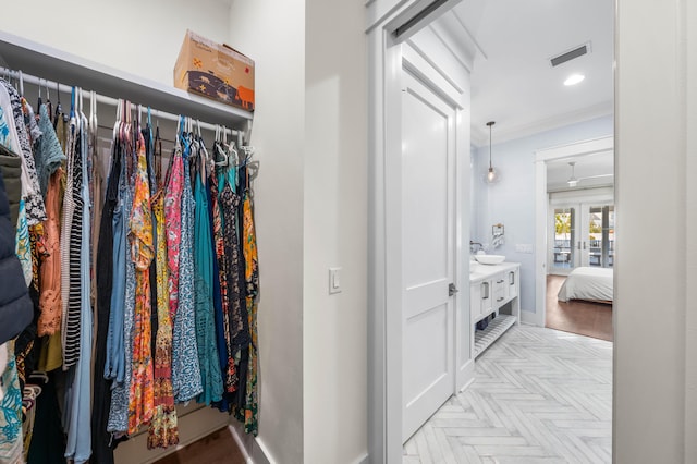 walk in closet featuring light parquet flooring, sink, and french doors