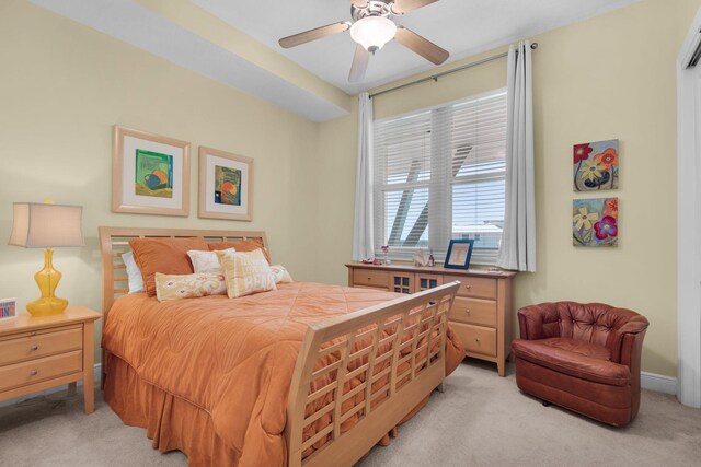 bedroom featuring light carpet, baseboards, and ceiling fan