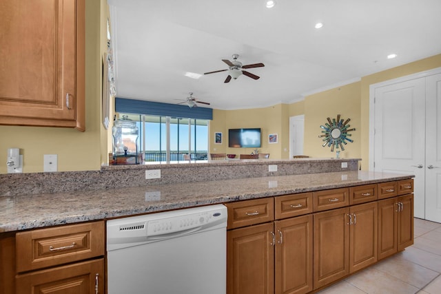 kitchen with brown cabinetry, light stone counters, dishwasher, and ceiling fan