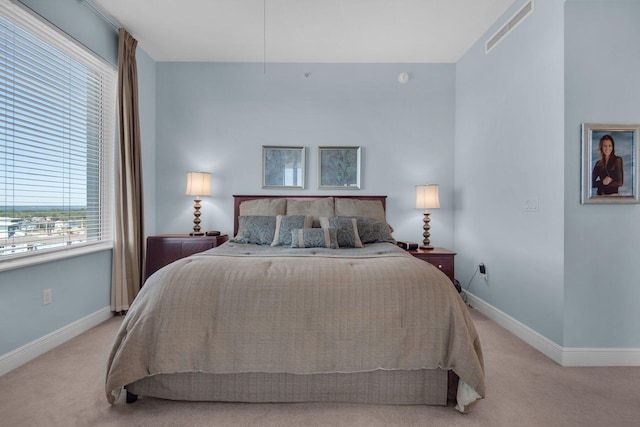 bedroom featuring visible vents, baseboards, and light colored carpet