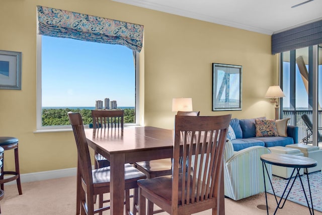dining space featuring crown molding, carpet flooring, and baseboards