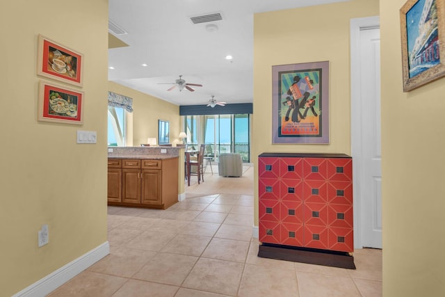 hall featuring recessed lighting, visible vents, baseboards, and light tile patterned flooring