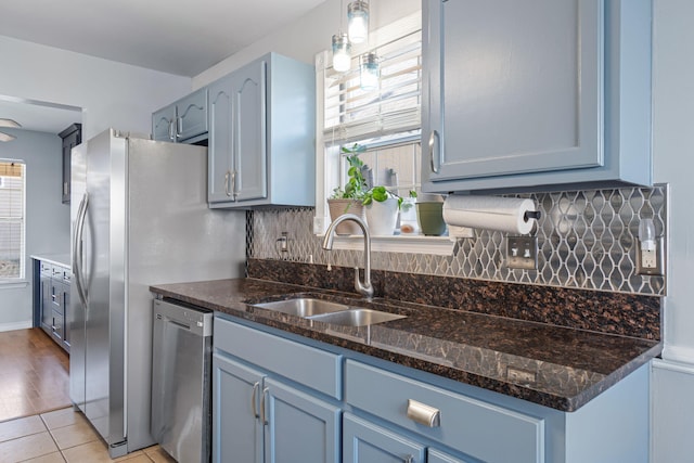 kitchen with pendant lighting, dishwasher, blue cabinets, and sink