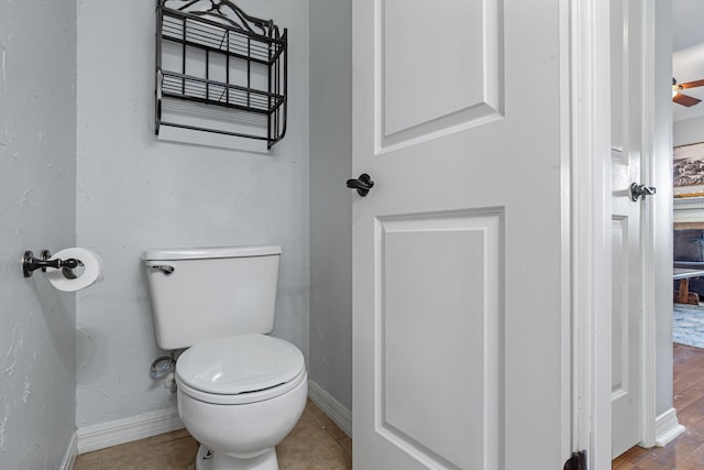 bathroom featuring tile patterned flooring, toilet, and ceiling fan