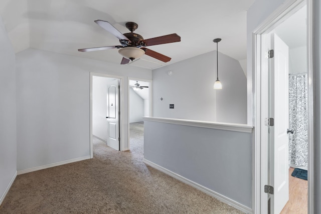 carpeted empty room featuring ceiling fan and vaulted ceiling