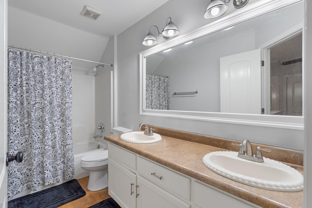 full bathroom featuring shower / bath combo, wood-type flooring, lofted ceiling, toilet, and vanity