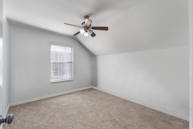 additional living space with ceiling fan, light colored carpet, and vaulted ceiling