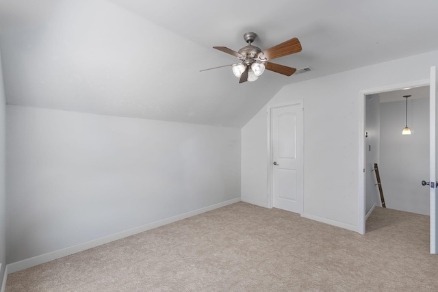 additional living space with ceiling fan, light colored carpet, and vaulted ceiling