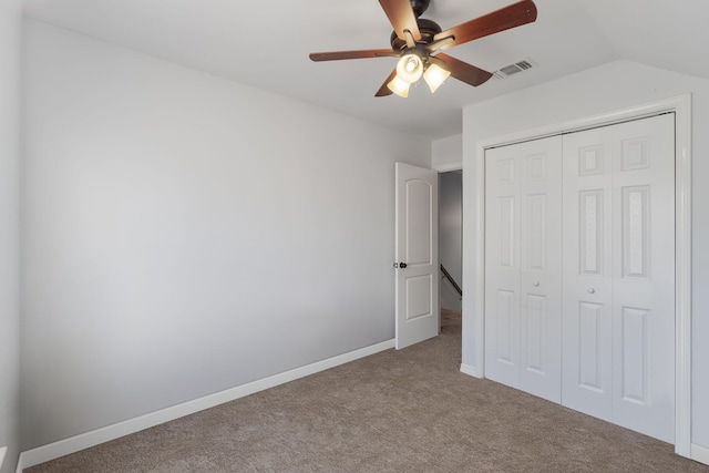 unfurnished bedroom featuring carpet flooring, ceiling fan, a closet, and vaulted ceiling