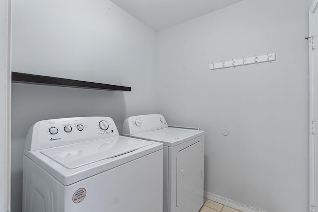 clothes washing area featuring washing machine and dryer and light tile patterned floors