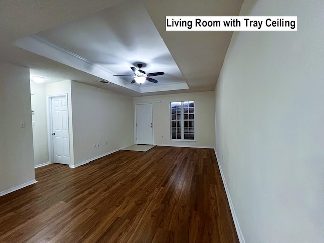 unfurnished room with ceiling fan, wood-type flooring, and a tray ceiling