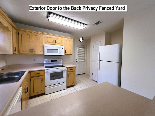 kitchen with a textured ceiling, white appliances, light tile patterned floors, and sink