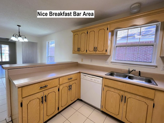 kitchen featuring dishwasher, sink, a notable chandelier, kitchen peninsula, and decorative light fixtures