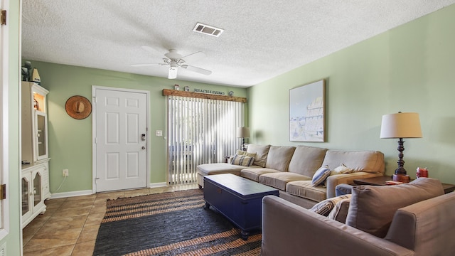 tiled living room with a textured ceiling and ceiling fan