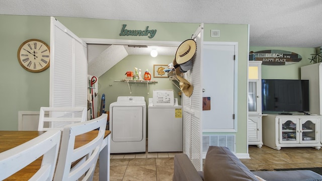 laundry area with light tile patterned floors, a textured ceiling, and independent washer and dryer