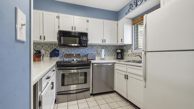 kitchen featuring sink, light tile patterned floors, tasteful backsplash, white cabinetry, and stainless steel appliances