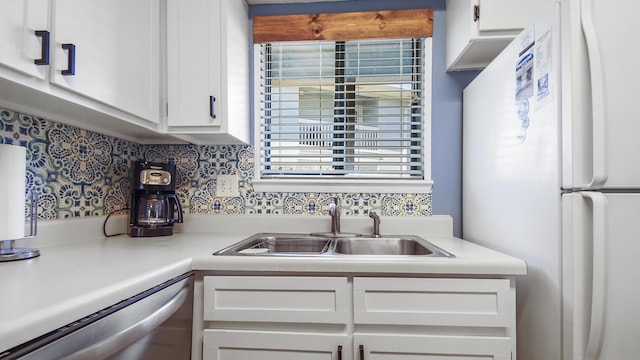 kitchen featuring white fridge, white cabinetry, stainless steel dishwasher, and sink