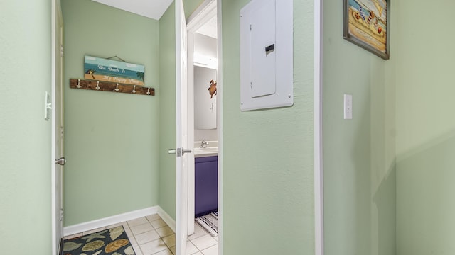 hallway featuring light tile patterned floors, electric panel, and sink