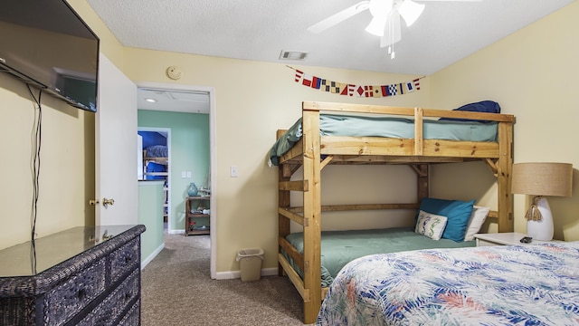 carpeted bedroom featuring ceiling fan and a textured ceiling