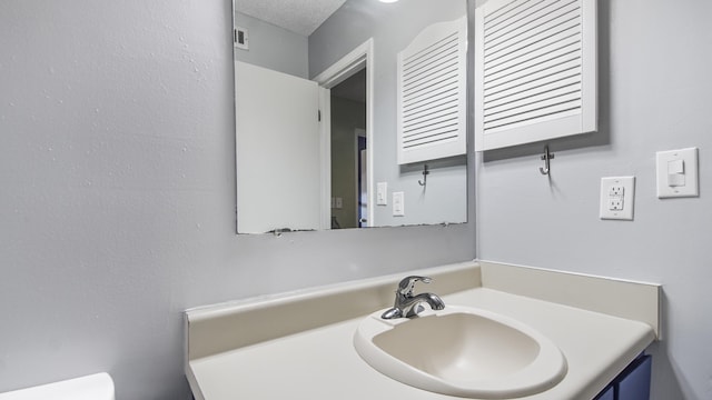 bathroom with a textured ceiling and vanity