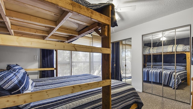 carpeted bedroom with a textured ceiling, two closets, and ceiling fan