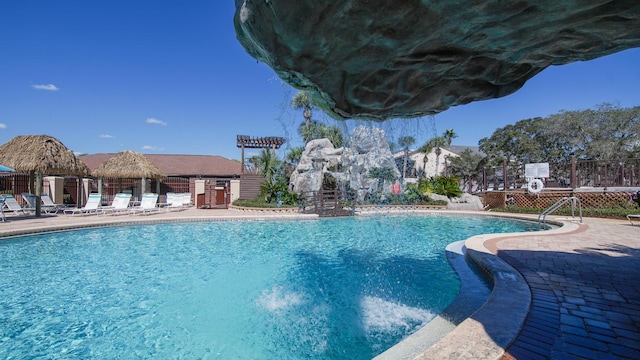 view of swimming pool with pool water feature and a patio area