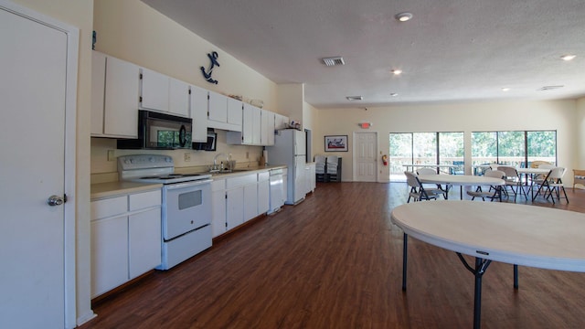 kitchen with sink, dark hardwood / wood-style floors, a textured ceiling, white appliances, and white cabinets