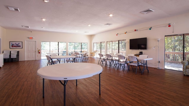 dining space featuring a textured ceiling and dark hardwood / wood-style floors