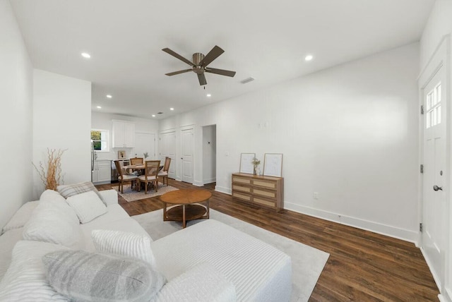 living room featuring dark hardwood / wood-style flooring, plenty of natural light, and ceiling fan