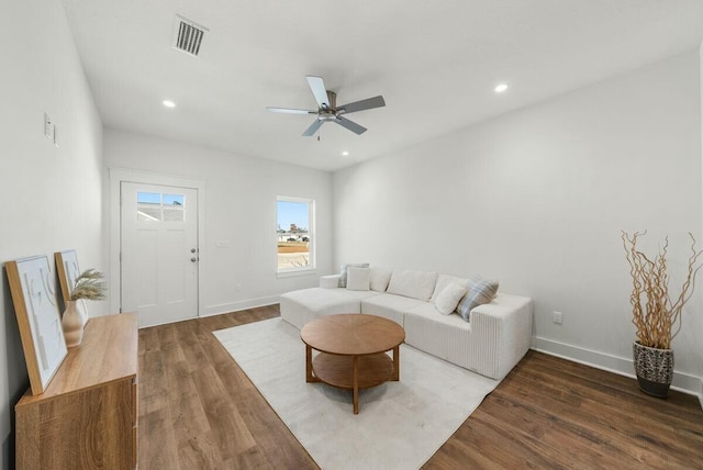 living room with ceiling fan and dark wood-type flooring