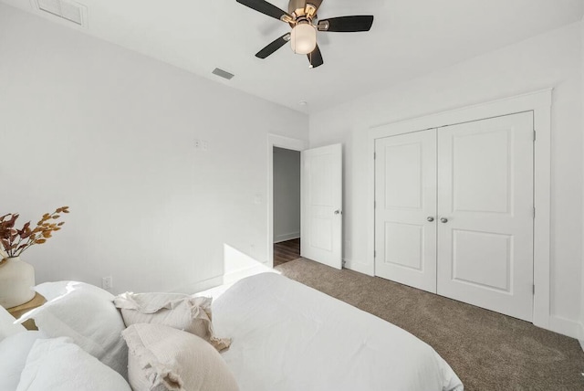 bedroom featuring a closet, dark carpet, and ceiling fan