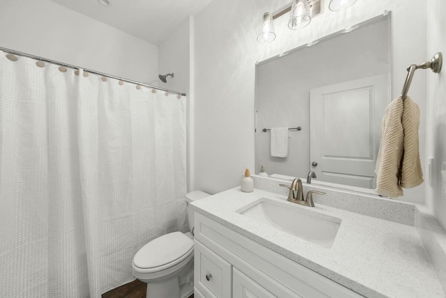 bathroom featuring vanity, toilet, and walk in shower