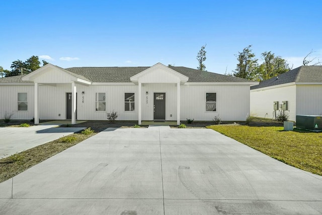 modern farmhouse style home with a front yard and central AC unit