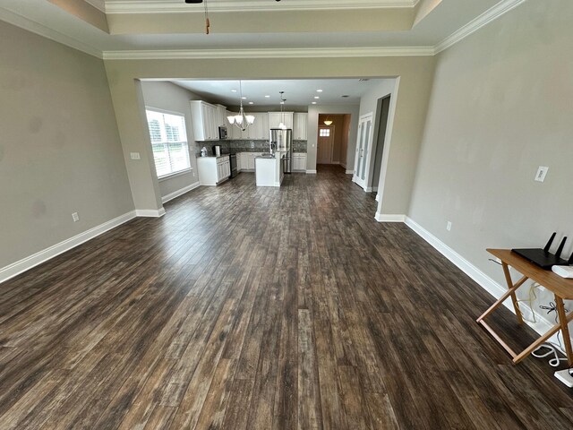 238 Partridge Ln, Freeport, FL 32439 - unfurnished living room featuring dark wood finished floors, a chandelier, crown molding, and a tray ceiling