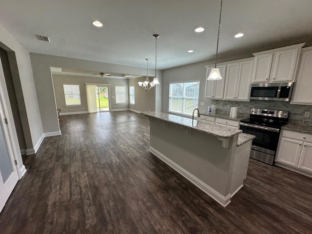 238 Partridge Ln, Freeport, FL 32439 - kitchen with appliances with stainless steel finishes, open floor plan, dark wood-style flooring, white cabinetry, and tasteful backsplash