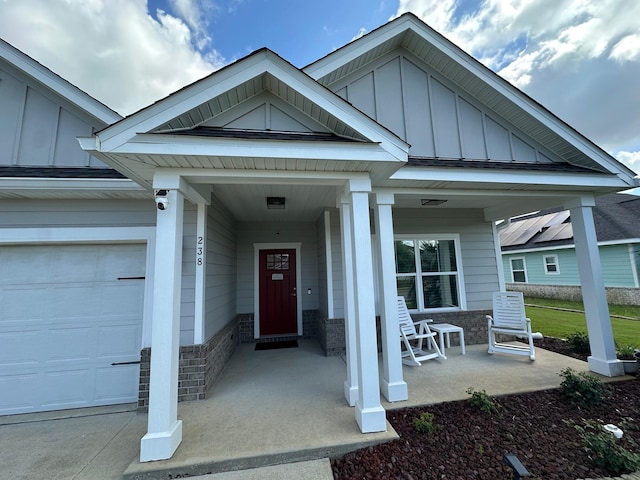 238 Partridge Ln, Freeport, FL 32439 - entrance to property featuring a porch, board and batten siding, a garage, and a surveillance system