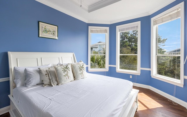 bedroom with hardwood / wood-style flooring, ornamental molding, and multiple windows