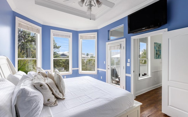 bedroom featuring dark wood-type flooring, ceiling fan, a tray ceiling, ornamental molding, and access to outside