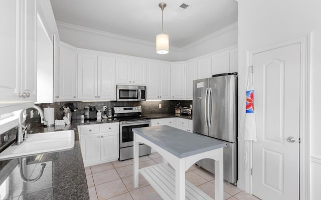 kitchen featuring sink, decorative light fixtures, appliances with stainless steel finishes, white cabinets, and backsplash