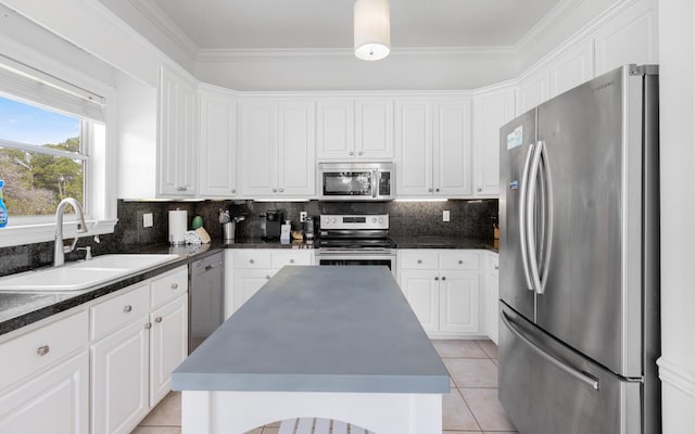 kitchen featuring stainless steel appliances, a kitchen island, sink, and white cabinets