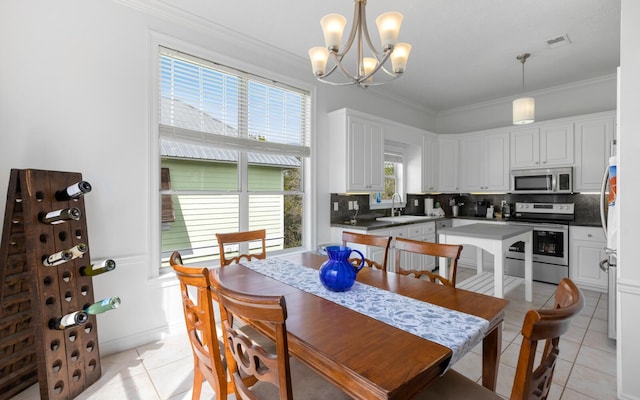 tiled dining space with crown molding, a chandelier, and sink