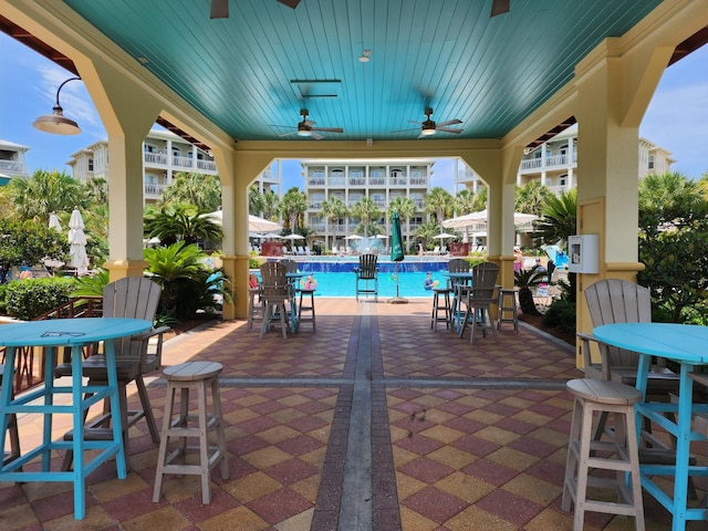 view of patio featuring a community pool and ceiling fan