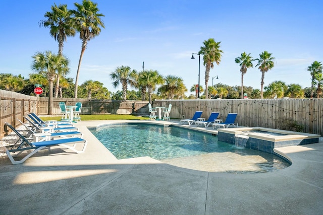 view of pool with a patio area and an in ground hot tub