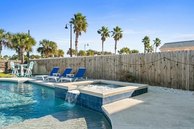 view of swimming pool with pool water feature, an in ground hot tub, and a patio